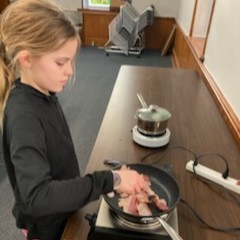 Participant frying bacon.