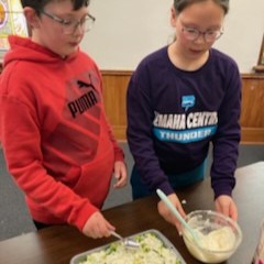 Participants spread dressing layer on 7-layer salad.