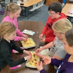 Participants add bacon bits to top of 7-layer salad.