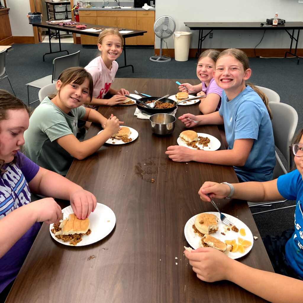 Cooking kids enjoying their sloppy joes.