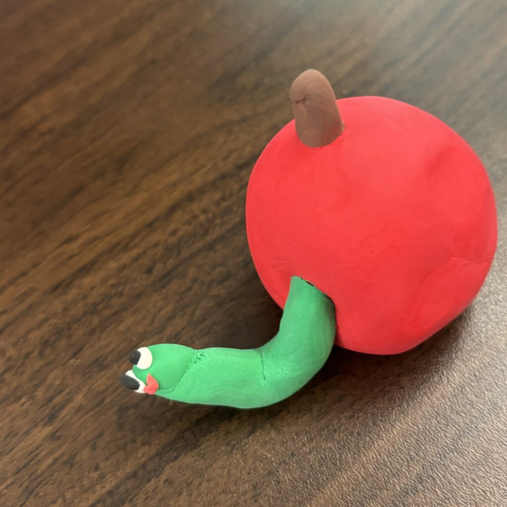 Worm in an apple done in clay.