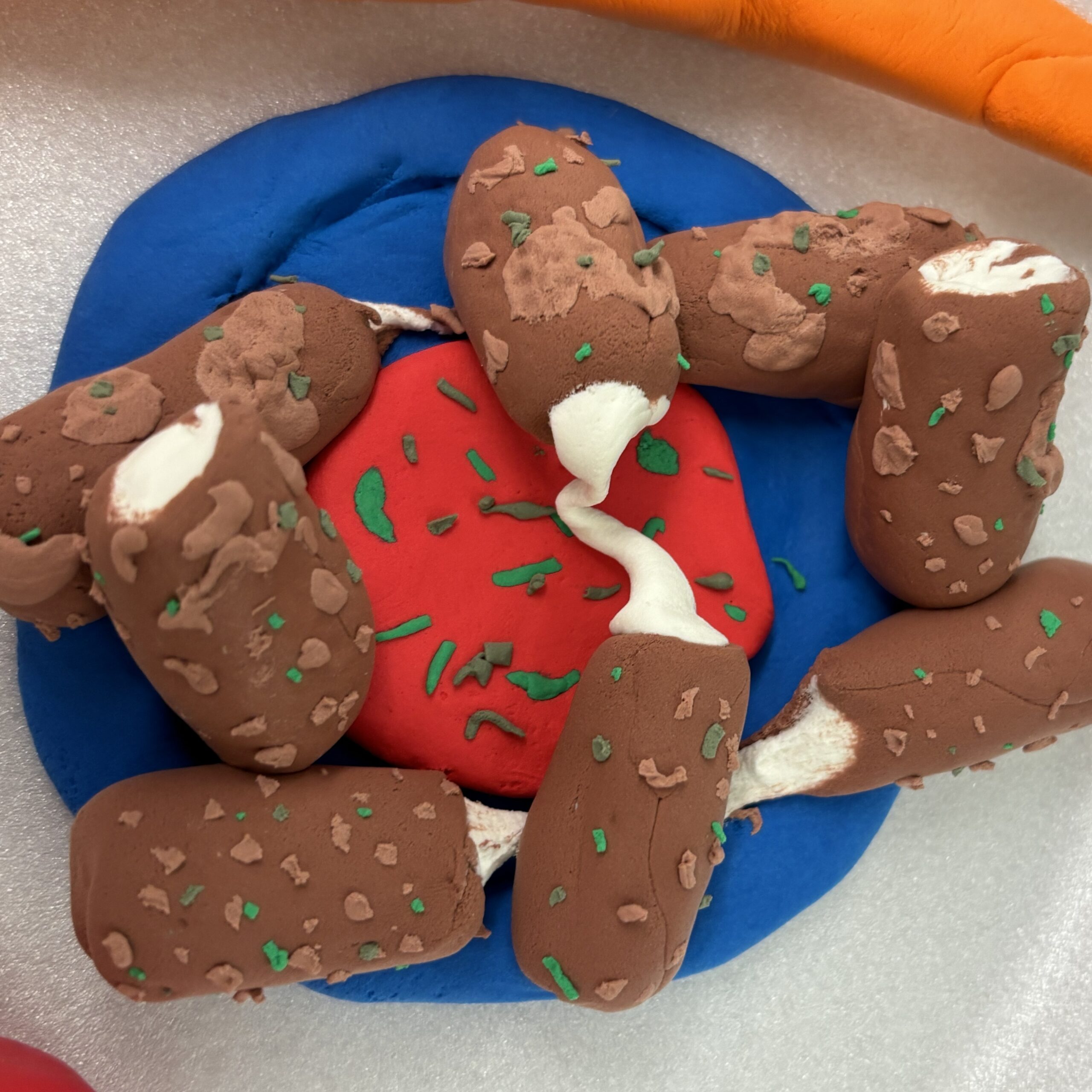 Plate of mozzarella sticks with marinara in clay.
