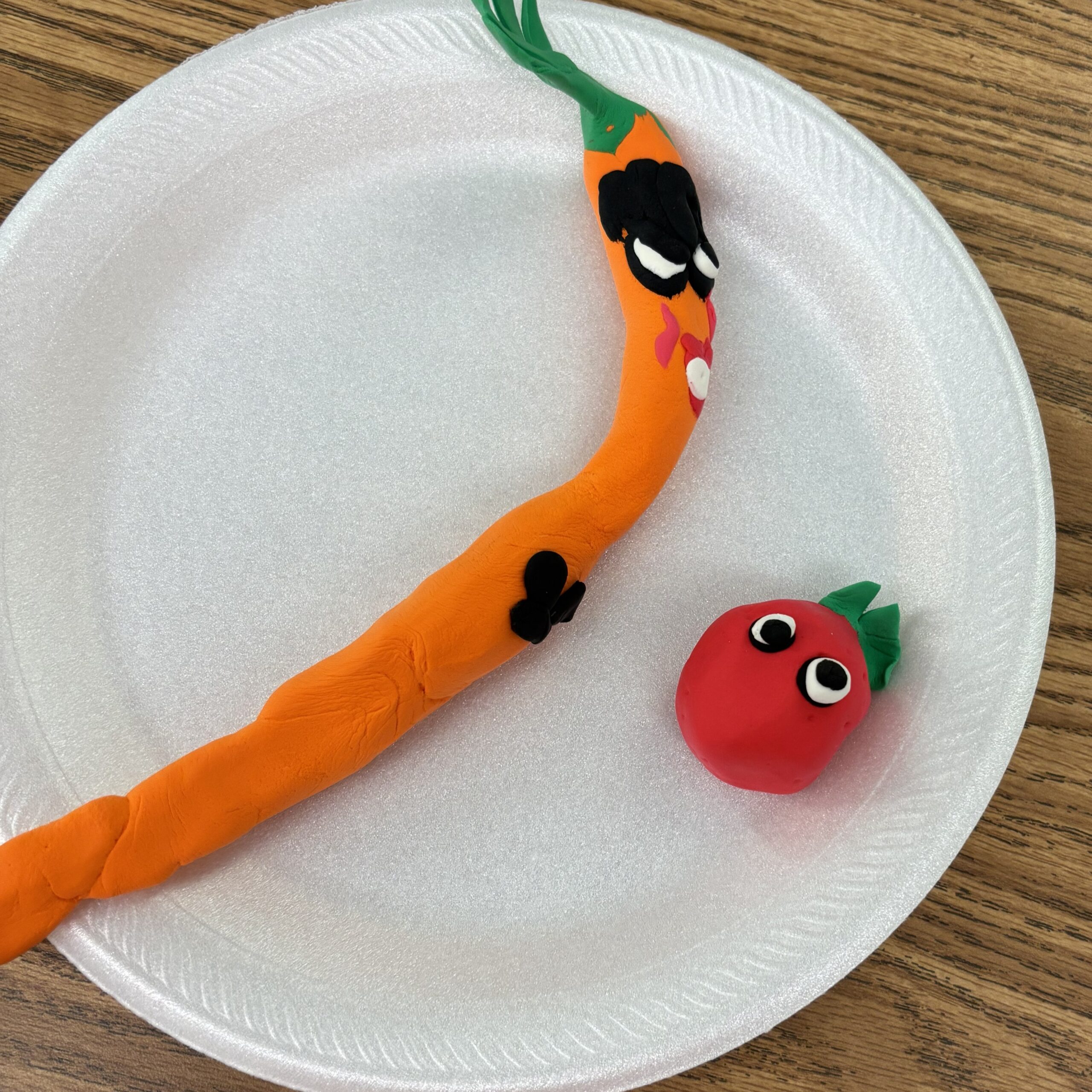 Quirky cartoon carrot and tomato in clay.