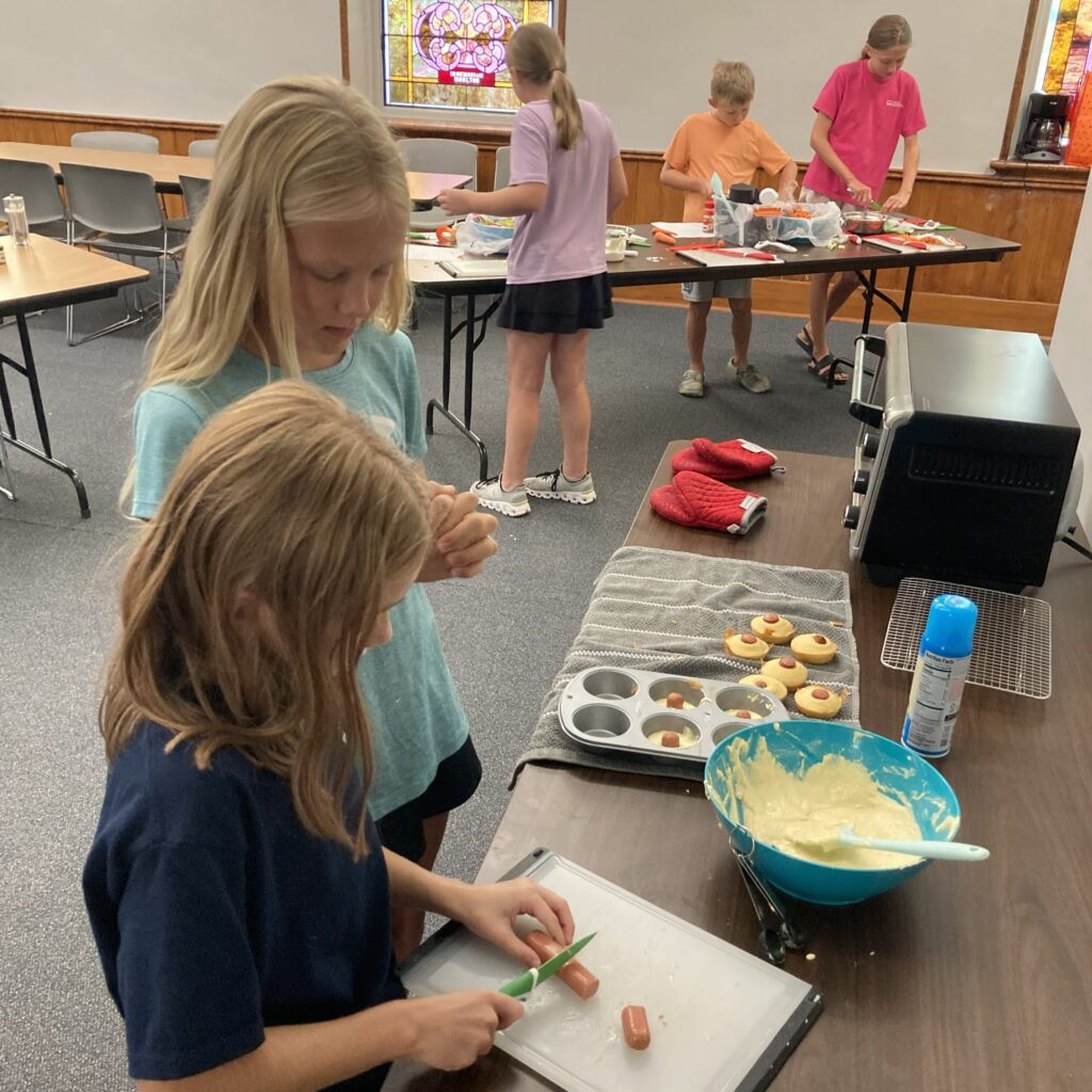 Putting the hot dog in the "corn muffin dogs."