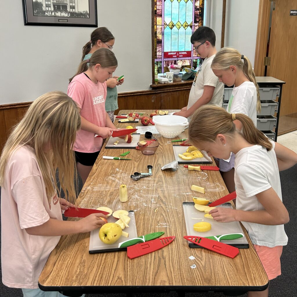Kids cutting apple slices for their dip.